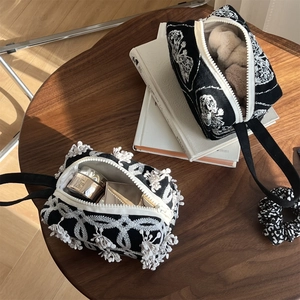 Black canvas handbag with ethnic embroidery and floral print in minimalist style