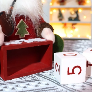 Weihnachts-Countdown-Kalender mit roter Holzbasis und einer Plüsch-Gnom-Puppe als Deko