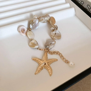 Macro detail of beaded starfish necklace with irregular shell beads and pearls