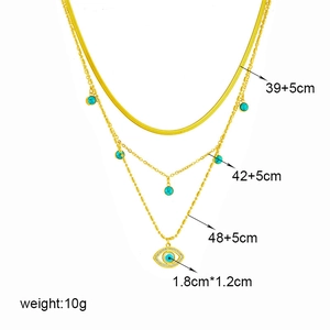 Gold multi-layer necklace with turquoise beads and evil eye pendant on white background