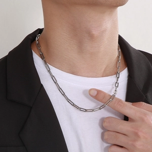 Detail of silver stainless steel paperclip chain necklace worn by a male model