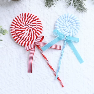 Festive red and blue candy cane ornaments with plush texture on cozy knit background
