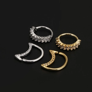 Close-up of gold and silver moon and star nose rings featuring sparkling zircon stones