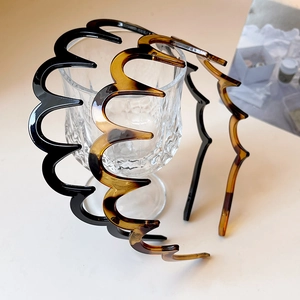Leopard print and black wavy hairbands set on a glass for a stylish hair accessory look