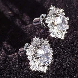 Elegant silver snowflake stud earrings with white zircon crystals on black velvet