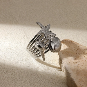 Close-up of silver-tone ring featuring starfish, shell, and seahorse with multi-layer design