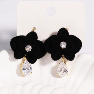 Macro detail of black floral tassel earrings with suede texture and zircon drop stones