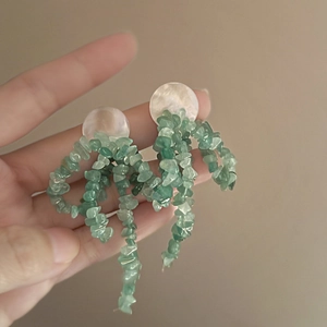 Boucles d'oreilles à nœud avec clous en nacre blanche et glands en pierre verte d'été