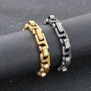 Close-up of vintage embossed titanium steel Cuban bracelets in gold and silver finish