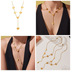 Close-up of gold Y-shaped necklace with multiple heart pendants on a fine chain