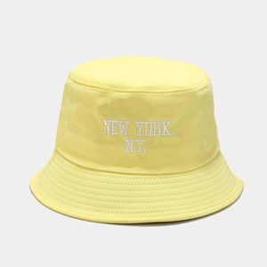 Detailed view of New York embroidery on a yellow cotton bucket hat with neat stitching