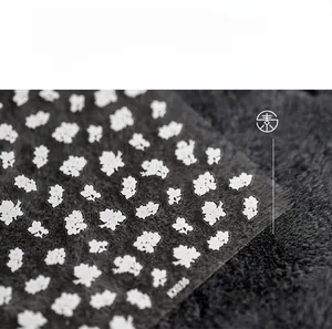 Macro shot of KK036 5D floral nail art stickers with delicate white flower patterns