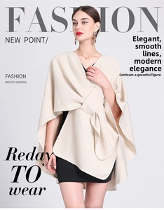 Detail of elegant beige knitted poncho with a stylish oversized bow tie collar design
