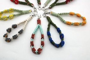 Detailed view of colorful hand-woven floral lanyards with silver lobster clasps