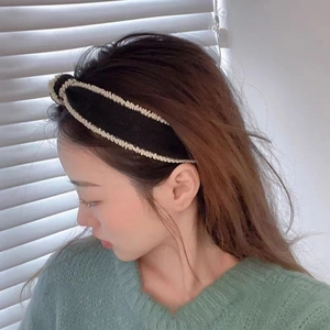Detail of black woven knotted headband with pearl trim showing high-quality texture