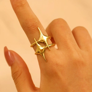 Detailed close-up of golden stainless steel irregular star ring on model finger