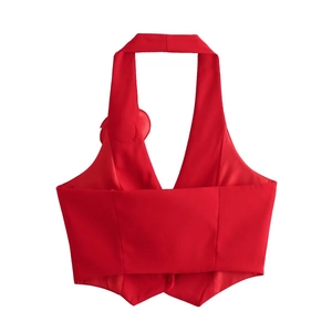 Detail of red halter neck top featuring a decorative flower accent and clean V-neckline
