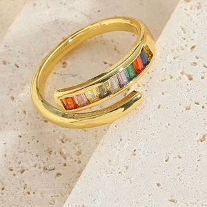 Close-up of gold adjustable ring with colorful baguette stones on beige stone base