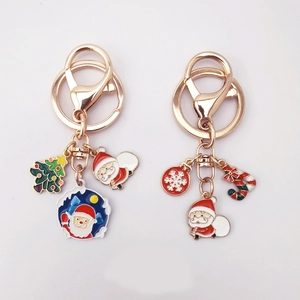 Christmas tree and Santa Claus enamel keychains with gold metal rings on white background