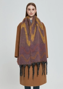 Macro detail of purple and yellow wavy knit pattern with black fringe tassels on scarf