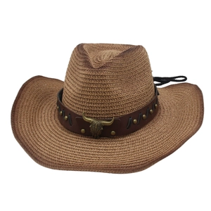 Detail of western straw cowboy hat with leather band and bronze bull head emblem
