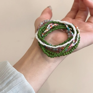 Close-up of a 7-piece Bohemian colorful beaded bracelet set worn on a person's wrist