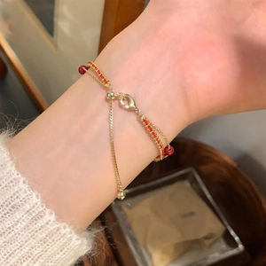 Gros plan du bracelet plaqué or 18 carats avec perles rouges et fermoir coulissant réglable