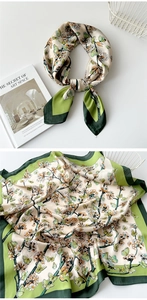 Detail of champagne silk scarf featuring floral butterfly print and green borders