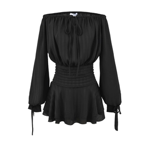 Détail de la taille élastique froncée et de l'ourlet à volants sur robe noire