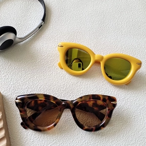 Close-up of retro cat-eye sunglasses in bright yellow and dark tortoiseshell colors