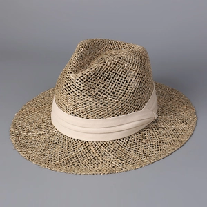 Detail of breathable woven texture and cream ribbon on a straw panama sun hat