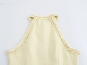 Détail de la robe en tweed dos nu avec bords effilochés et design à boutonnage simple