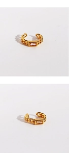 Detailed close-up of a gold chain cuff earring with an elegant rectangular clear gemstone