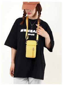 Detailed shot of yellow nylon phone bag with adjustable strap and heart zipper detail