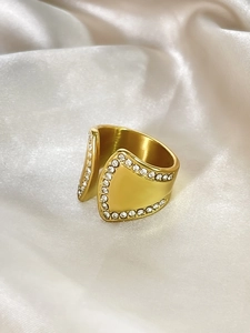 Detailansicht eines 18K vergoldeten breiten Rings mit Zirkonia auf weichem Satinstoff