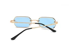 Macro view of blue rimless sunglasses with gold spiral metal temple detail