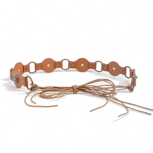 Close-up of brown leather patchwork belt with turquoise accents and bronze metal rings