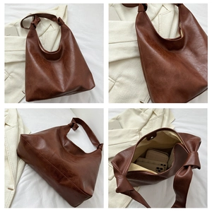 Detail view of brown PU leather tote with large knot accents and magnetic closure