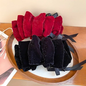 Détail de pinces à cheveux en velours avec de longs rubans et une finition pailletée