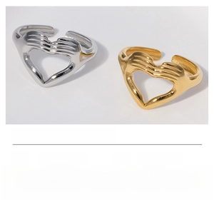Detail of stainless steel heart gesture open rings in silver and gold plating