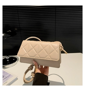 Détail du sac à main beige en similicuir matelassé avec bandoulière à nœud unique