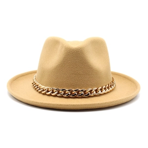 Detail of camel wool fedora hat featuring a chunky gold metal chain link decoration