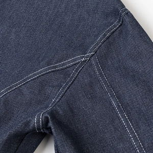 Gros plan sur la texture du denim bleu foncé avec des coutures blanches contrastées