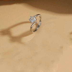 Detail of silver ring with six-prong set clear stone and adjustable band design