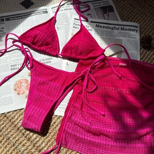 Detailed texture of hot pink ripple fabric on bikini and matching mini skirt