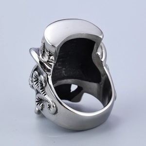 Macro shot of silver retro punk skull ring showing thick band and polished metal texture