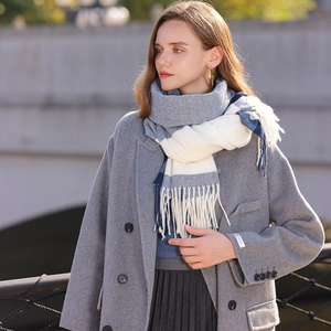 Blue and white checkered tassel scarf paired with a grey double-breasted wool coat