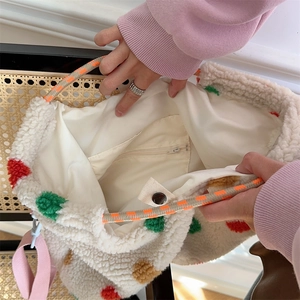 Detail view of plush striped bag with inner zipper pocket, snap closure, and woven handle