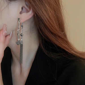 Detail of vintage silver fringe earrings with dark gemstones showing the chain texture