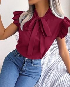 Detail of burgundy short sleeve chiffon blouse featuring a bow neck and ruffle sleeves
